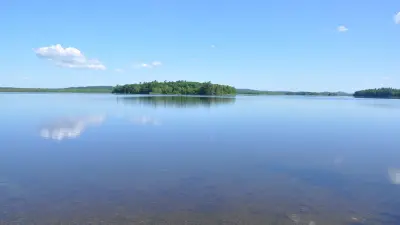 Wooded islands and calm water on Androscoggin Lake, Maine.
