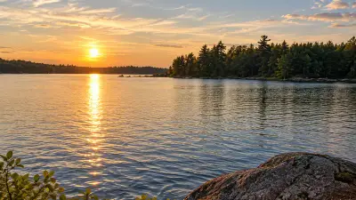 AI illustration of Lower Patten Pond, with a low wooded shoreline and sunset over the water