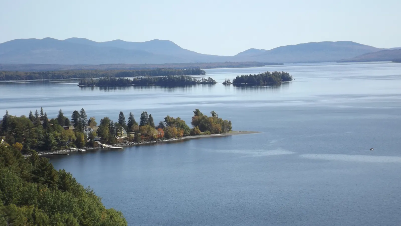 Forested islands and distant mountains across the calm open water of Moosehead Lake, Maine